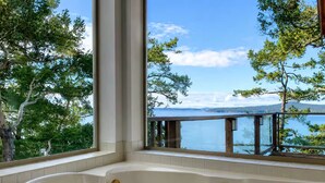 A bathtub with a view of a lake and trees. - SaliHaven: Oceanfront 3 BR 3 Beds 3.5 Ba + Gym (Pender Island)