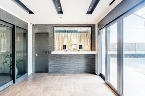 A modern reception area with a reception desk, a door, and a large window. - ESLEAD HOTEL Namba South 1 (Osaka)