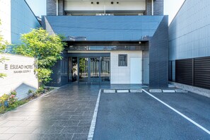 The entrance of the Eslead Hotel with a modern design, including a glass door entrance and a paved driveway. - ESLEAD HOTEL Namba South 1 (Osaka)