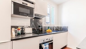 Una cucina moderna con forno a incasso, microonde e finestra sopra il lavello.