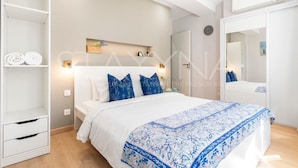 Una camera da letto con un letto, un armadio, uno specchio e uno scaffale con asciugamani.