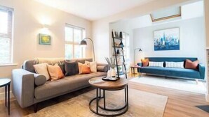 A modern living room with a sofa, a coffee table, and a bookshelf.