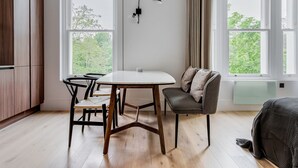 Una cocina moderna con armarios de madera, una mesa redonda para comer y un banco empotrado con cojines.