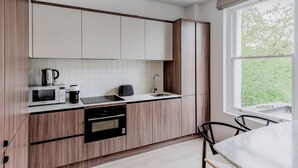 Una cocina moderna con armarios de madera, microondas, cafetera y tostadora.