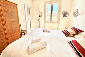 A hotel room with a bed, a wardrobe, a chair, and a window with a view. - Ortigia Terrazza Su Due Mari (Syracuse)