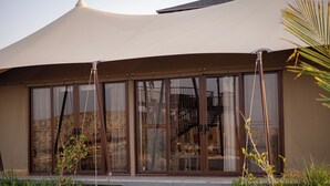 Een modern gebouw met grote glasramen, een gebogen dak en een trap naar de ingang.