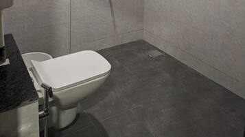 Ein modernes Badezimmer mit Toilette, Dusche und Waschbecken.