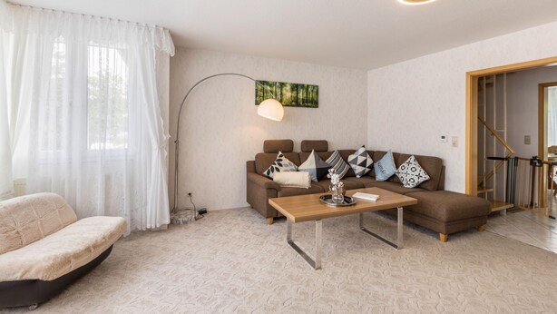 Un salon avec un canapé, une table basse, une lampe et un tableau au mur.