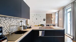 Una cocina moderna con una isla central, un lavaplatos integrado y un salpicadero con diseño a cuadros.