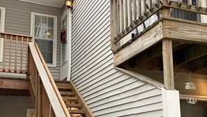 Un escalier en bois menant à un balcon doté d’une balustrade.