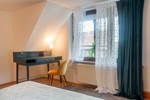 A bedroom with a desk, chair, and a window with curtains. - Apartment 'Wohnung Mit Dachterrasse' with Private Terrace and Wi-Fi (Absberg)
