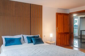 A bedroom with a bed, pillows, a bedside table with a lamp, and a wooden door leading to a balcony. - Apartment 'Wohnung Mit Dachterrasse' with Private Terrace and Wi-Fi (Absberg)