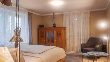 A bedroom with a bed, a wooden cabinet, a chair, and a small table.