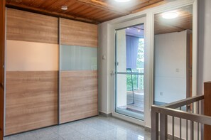 A room with a sliding door leading to an outdoor area, a wooden ceiling, and a tiled floor.