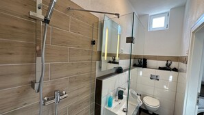 Une salle de bain moderne équipée d’une douche, d’un lavabo et de toilettes.