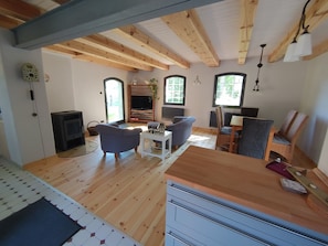 Ein gemütliches Wohnzimmer mit Kamin, Sofa und Essbereich.