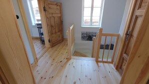 A wooden staircase leading to a second floor with a window and a door. - Holiday Home 'Melkerhaus' with Private Terrace, Private Garden and Wi-Fi (Boitze-Neetzendorf)