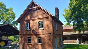 A brick building with a pitched roof, multiple windows, and a chimney. - Holiday Home 'Melkerhaus' with Private Terrace, Private Garden and Wi-Fi (Boitze-Neetzendorf)