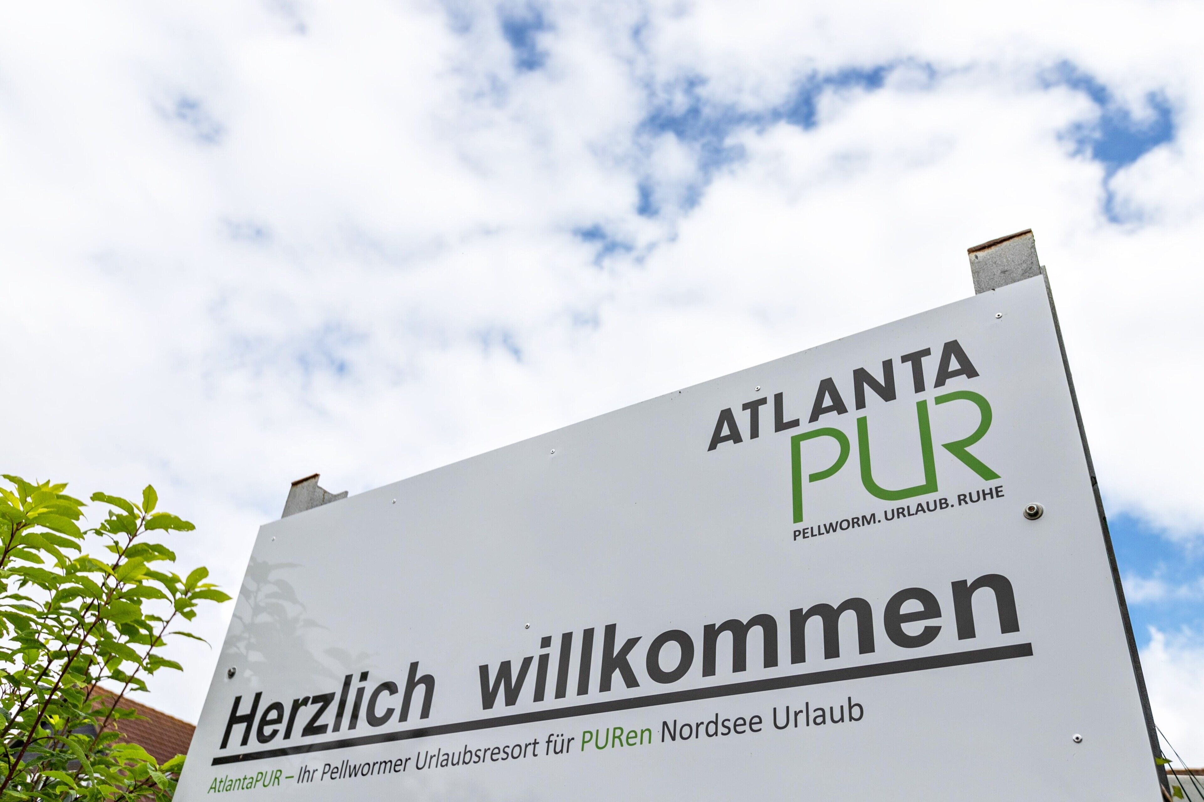 Ein Schild mit der Aufschrift 'Herzlich willkommen' und 'ATLANTA PUR', das eine freundliche Begrüßung für Gäste anzeigt.