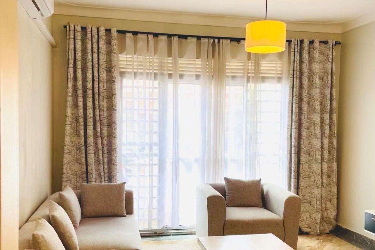 A living room with two sofas, a coffee table, and a yellow pendant light.