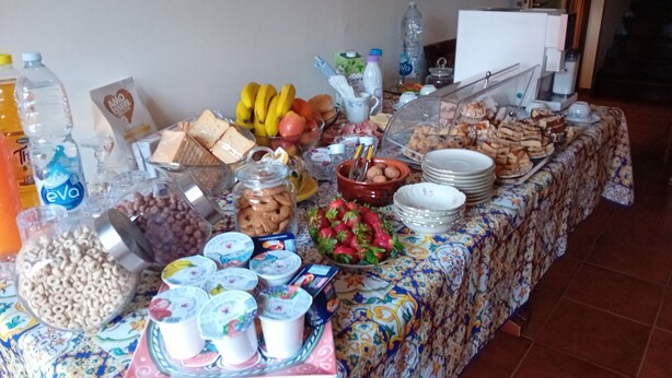 A buffet table with various food items, including fruits, sandwiches, and dairy products. - Giardino del Sole (Ascoli Piceno)