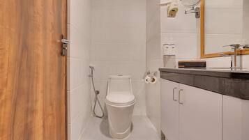 A modern bathroom with a toilet, shower, and vanity.
