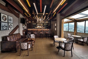 A bar area with wooden furniture, a bar counter, and framed pictures on the wall. - KEYS PRIMA BY LEMON TREE HOTELS (Darjeeling)