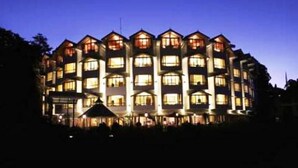 Un hôtel à plusieurs étages, doté d’une façade symétrique, de nombreux balcons et de fenêtres de taille uniforme.