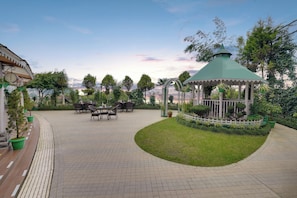 An outdoor patio area with a gazebo, seating arrangements, and potted plants. - KEYS PRIMA BY LEMON TREE HOTELS (Darjeeling)