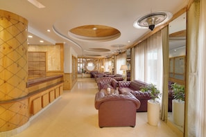 A hotel lobby with a long seating area, wooden paneling, and a large mirror. - KEYS PRIMA BY LEMON TREE HOTELS (Darjeeling)