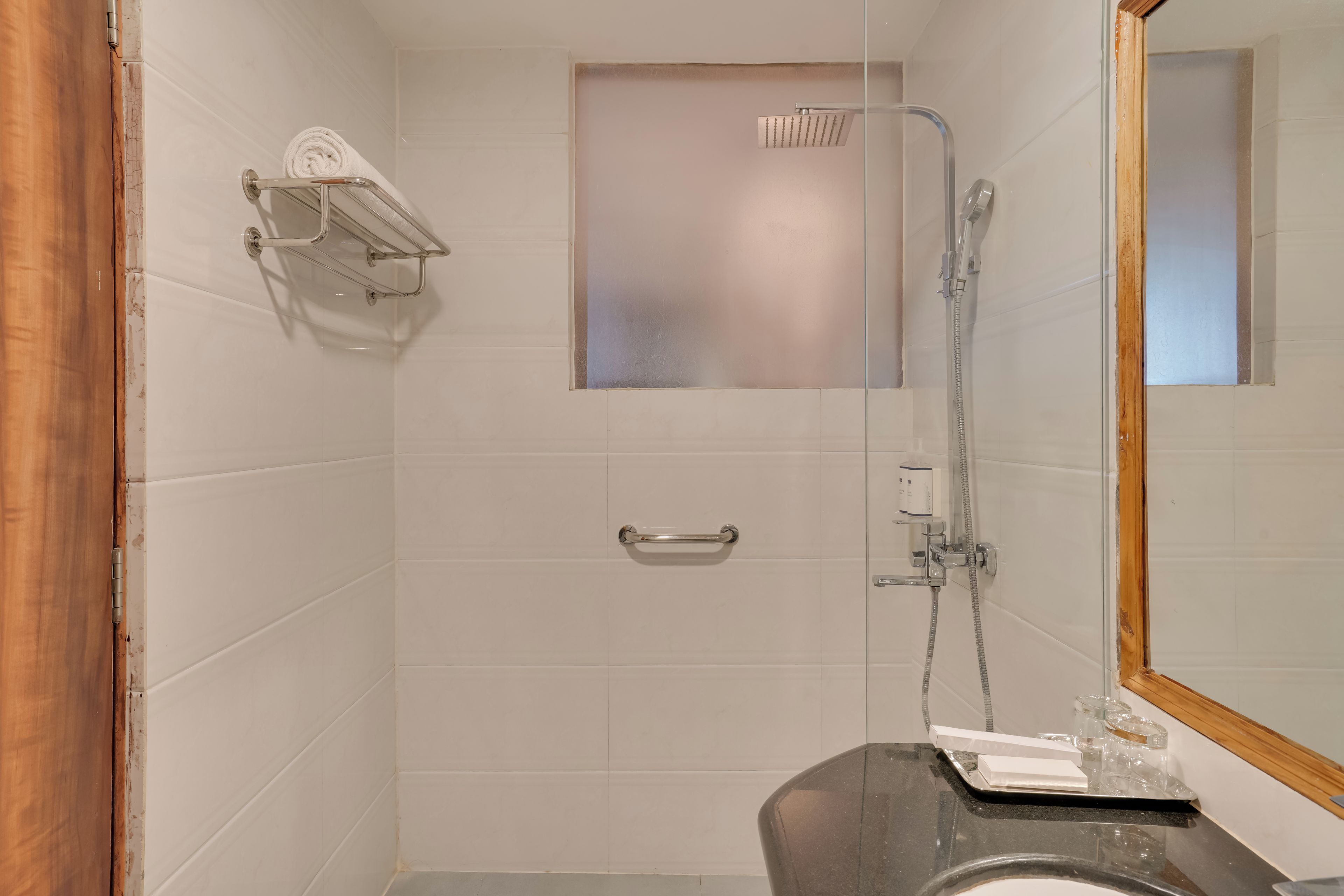 Een badkamer met een douche, toilet en wastafel.