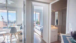 Moderni hotellihuone, jossa on parveke, ruokailutila ja kylpyhuone.