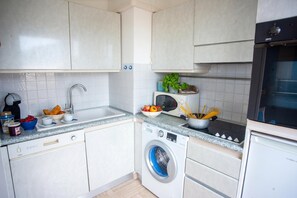 A compact kitchen with a washing machine, a microwave, and a sink. - Eden Palace 9 Attico 200m from the Promenade, Menton, France (Menton)