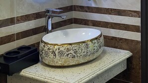 A bathroom with a large oval mirror, a handheld hair dryer, and a wall-mounted hairdryer. - Thuong Hai Hotel - by Bay Luxury (Hanoi)