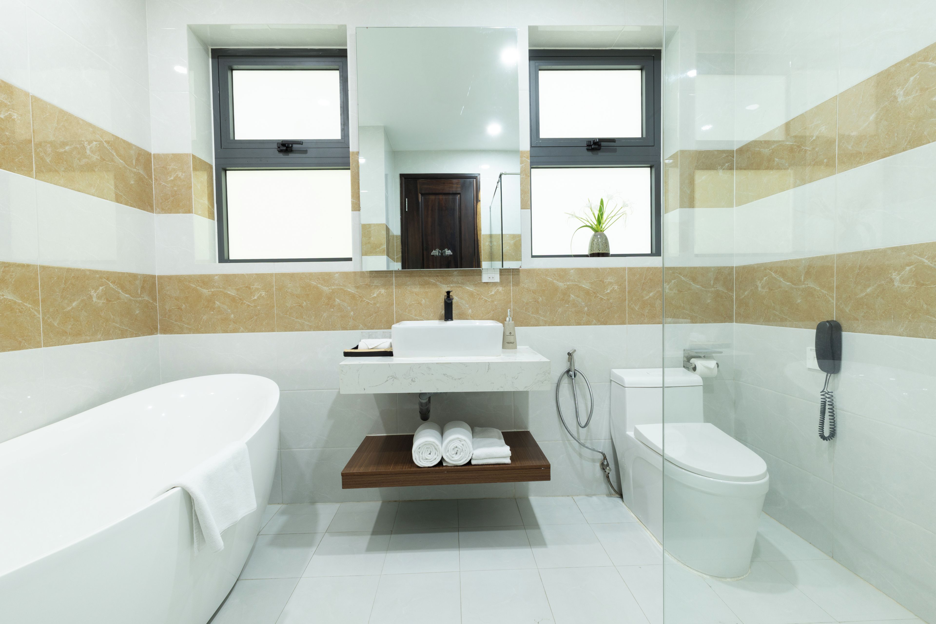 A modern bathroom with a bathtub, a sink, a toilet, and a shower.