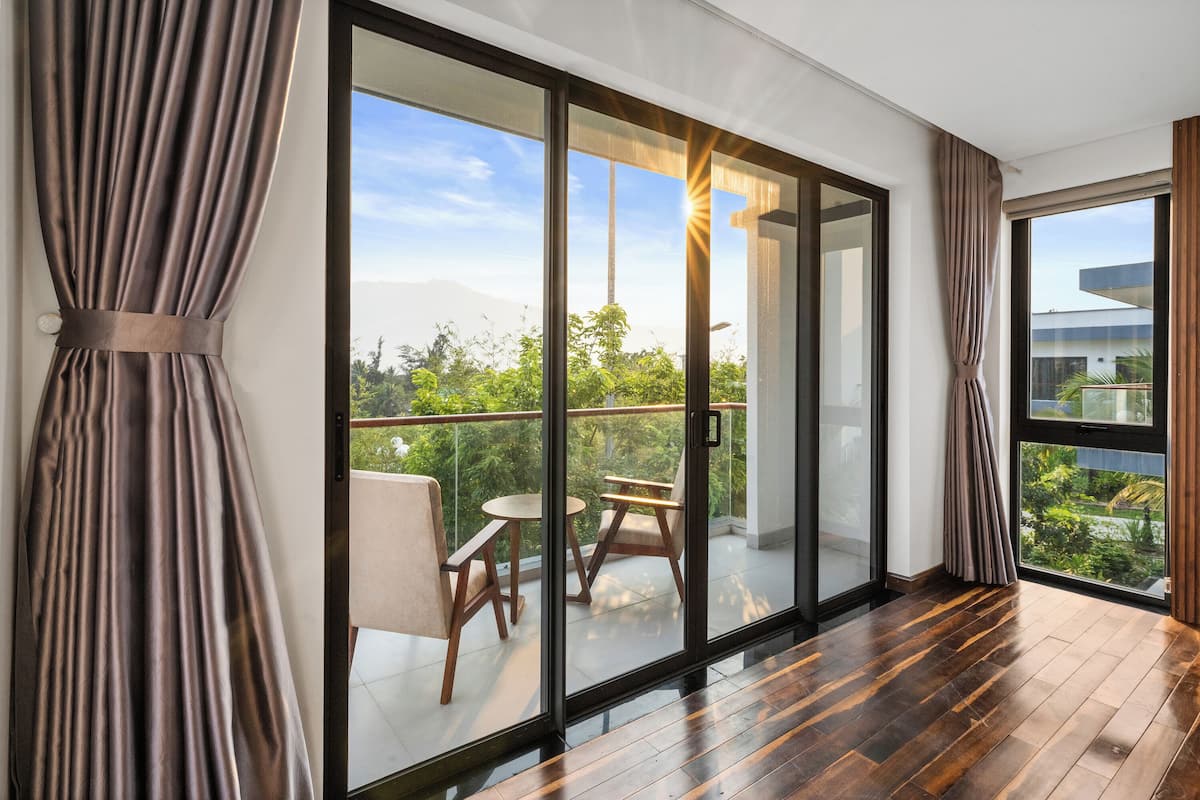A modern room with a large sliding glass door leading to a balcony with outdoor furniture.