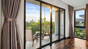 A modern room with a large sliding glass door leading to a balcony with outdoor furniture.