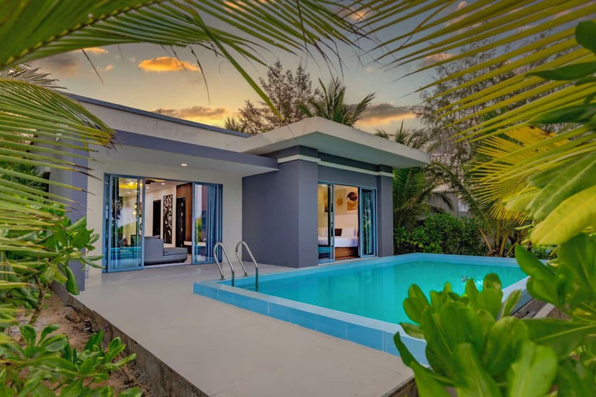 A modern house with a swimming pool, glass doors, and a patio area.