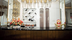 A bar area with a decorative Christmas tree, a wine rack, and a golden statue. - Hoa Hong 1 Hotel - by Bay Luxury (Hanoi)