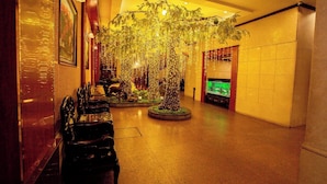 A lobby with a central decorative tree, seating area, and a fish tank. - Hoa Hong 1 Hotel - by Bay Luxury (Hanoi)