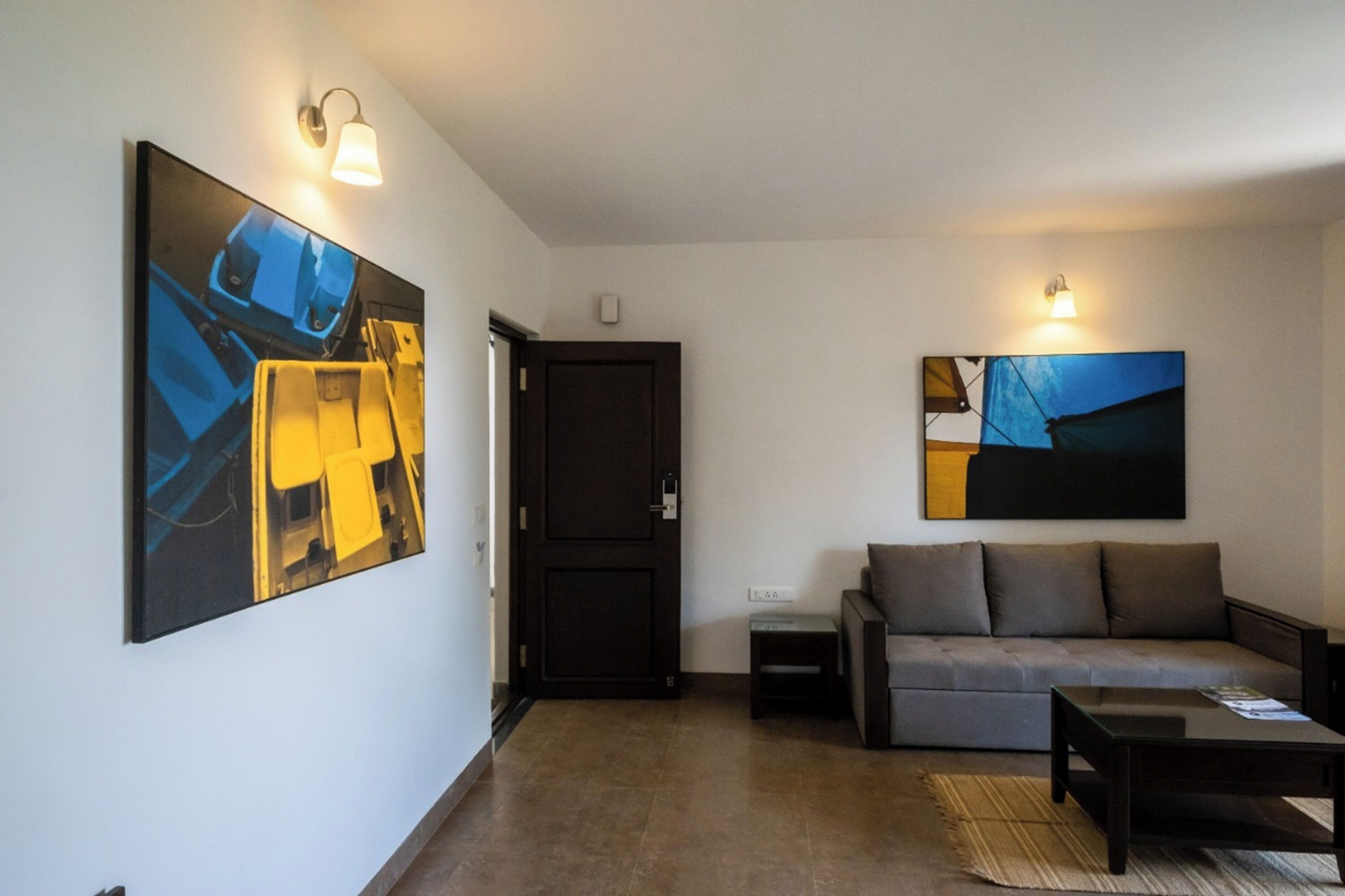A modern living room with a sofa, coffee table, and artwork on the walls.