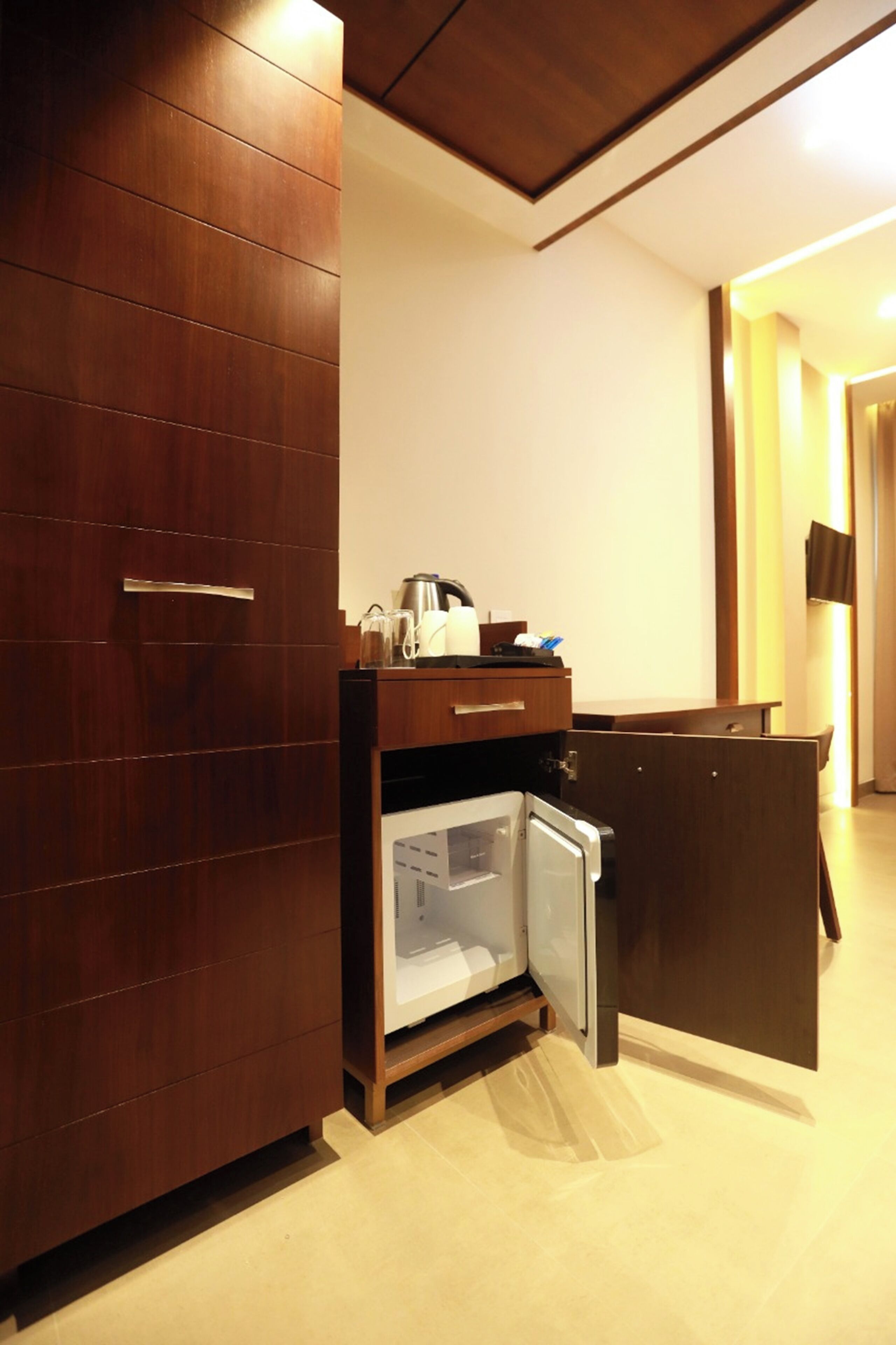 A compact kitchenette with a refrigerator, microwave, and coffee maker.