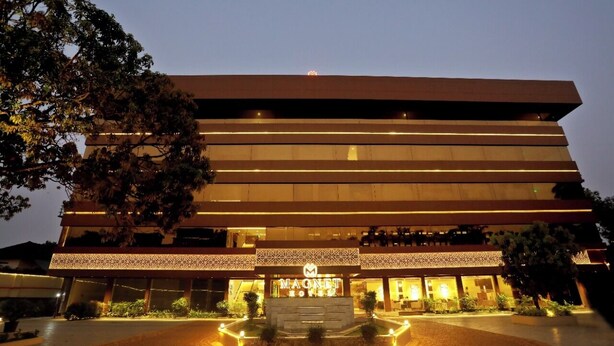 A modern hotel with a flat roof, multiple floors, and a well-lit entrance. - Magnet Hotel (Kannur)
