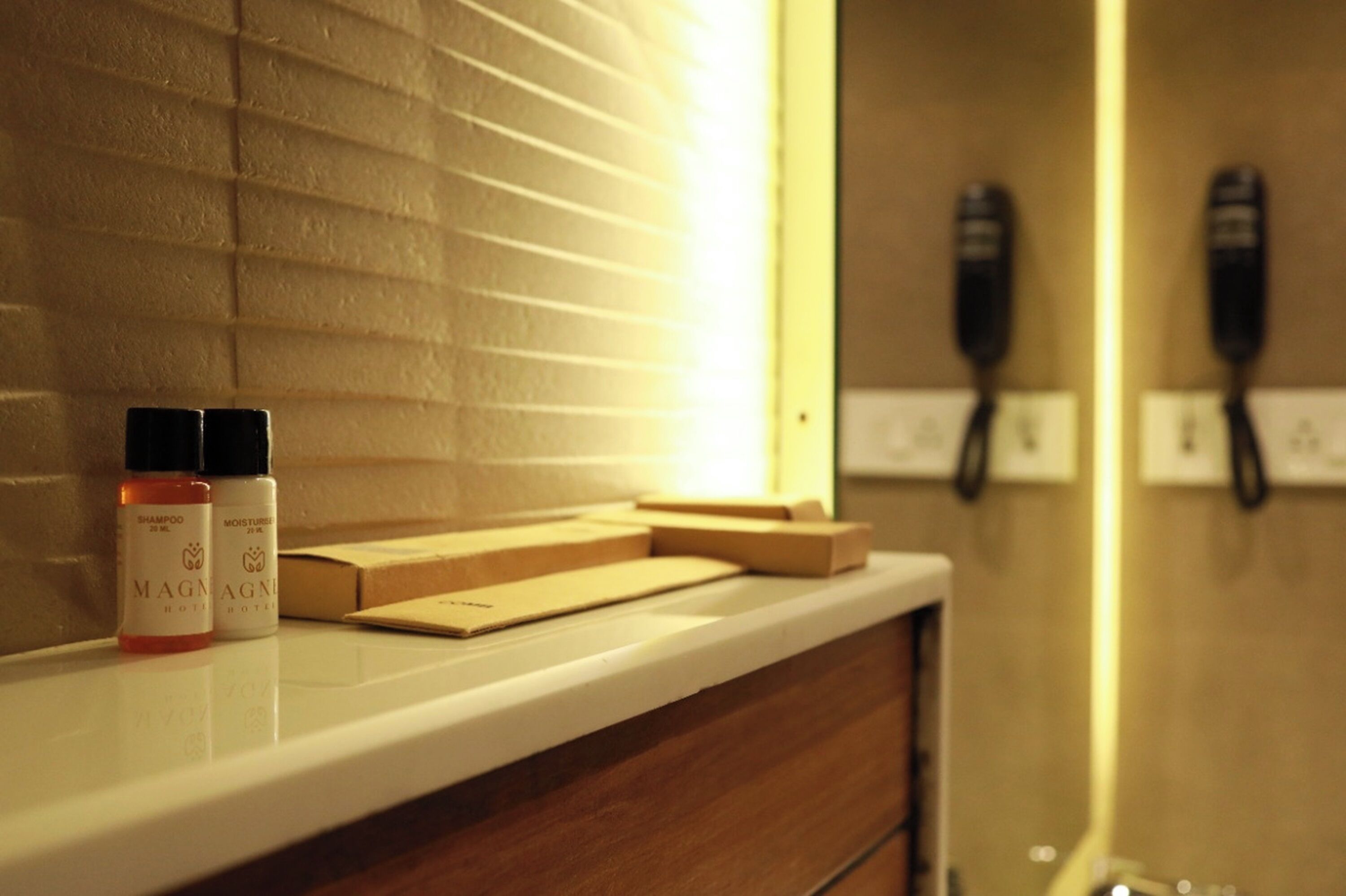 Una encimera de baño con artículos de aseo y un espejo.