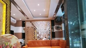 A modern living room with a sectional sofa, a coffee table, and a decorative wall panel.