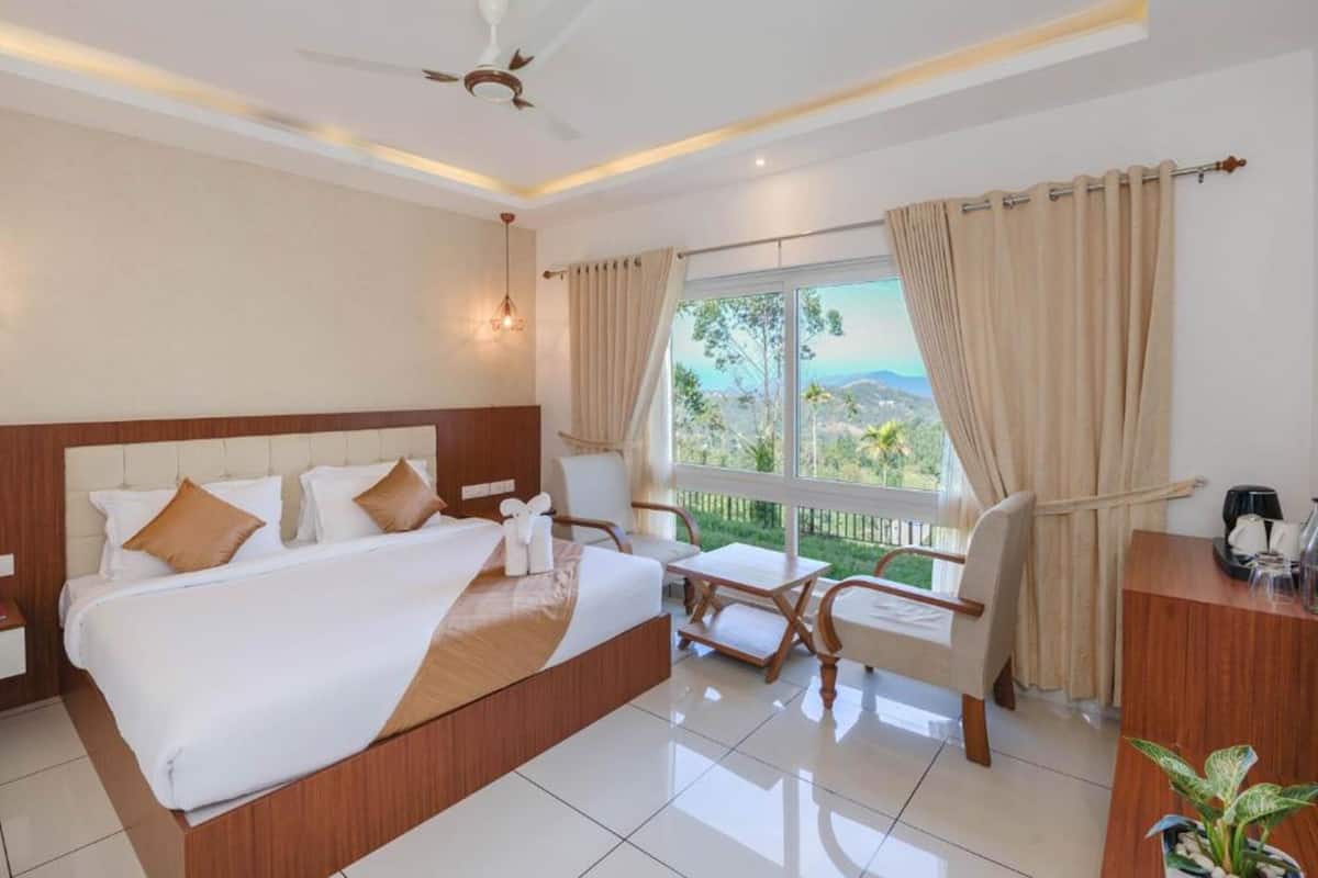 A hotel room with a large bed, a desk, a chair, and a view of the outdoors.