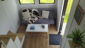 Una habitación con sofá, una mesa de centro, un libro y una planta.