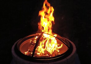 A circular fire pit with flames. - Taranaki Creekside TUI by Tiny Away (Midhirst)
