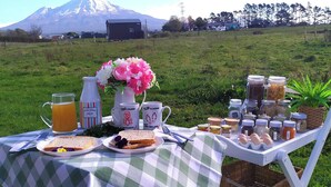 Ein Picknick mit Essen, Getränken und Blick auf einen Berg.