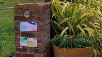 A brick wall with two signs, one labeled "Taramaki TUJ" and the other "Taramaki KEA".